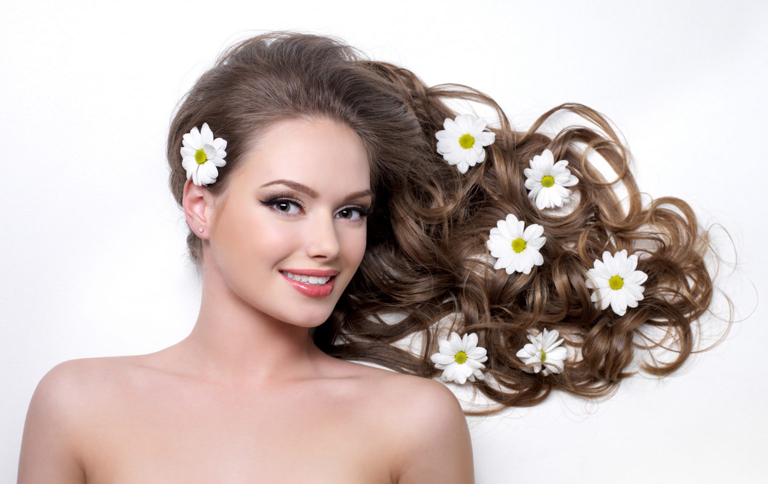 Smiling woman with camomiles in hair